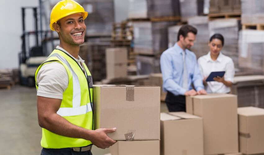 a man wearing a safety vest and holding a box